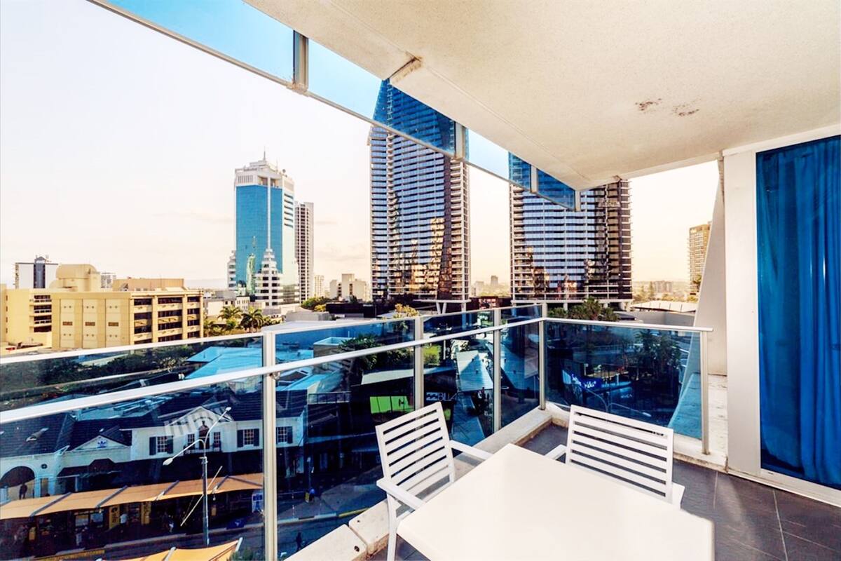 Een moderne hotelkamer met een balkon met uitzicht op een stadsgezicht.