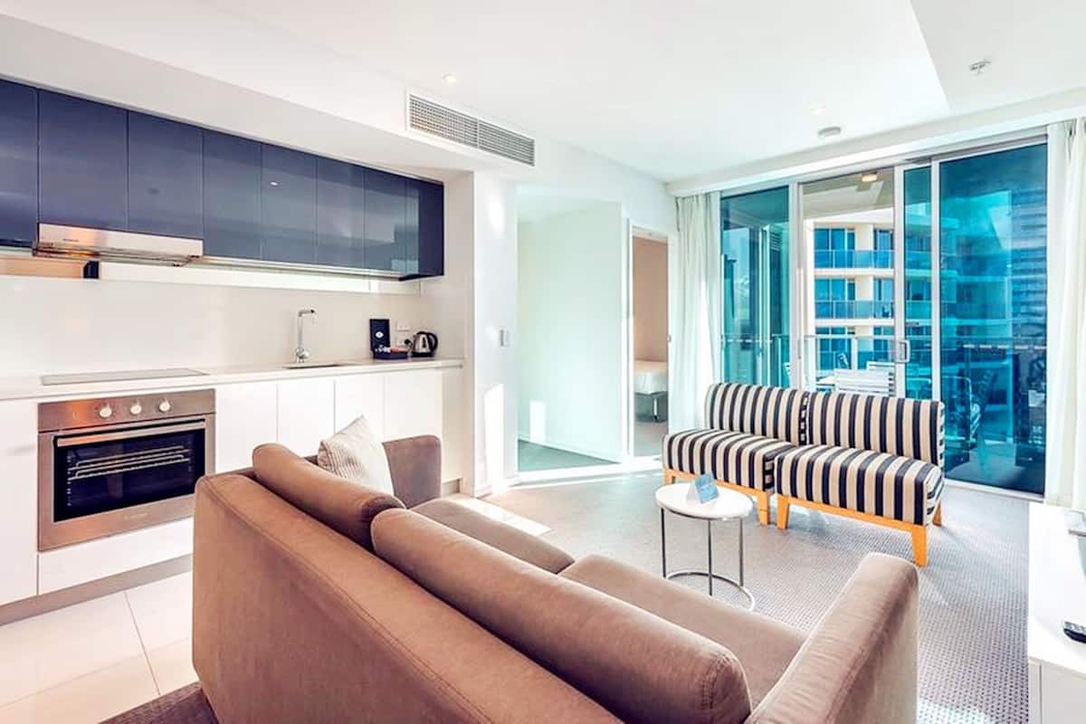 Een modern appartement met keuken, woonkamer en grote schuifpuien naar een balkon.