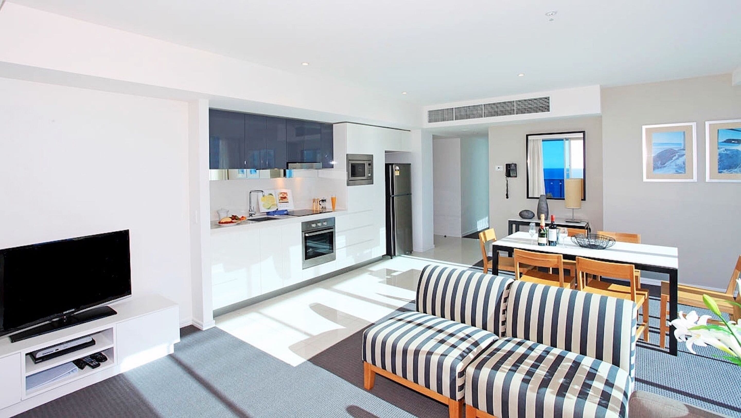 A modern apartment with a kitchen, dining area, and living room.