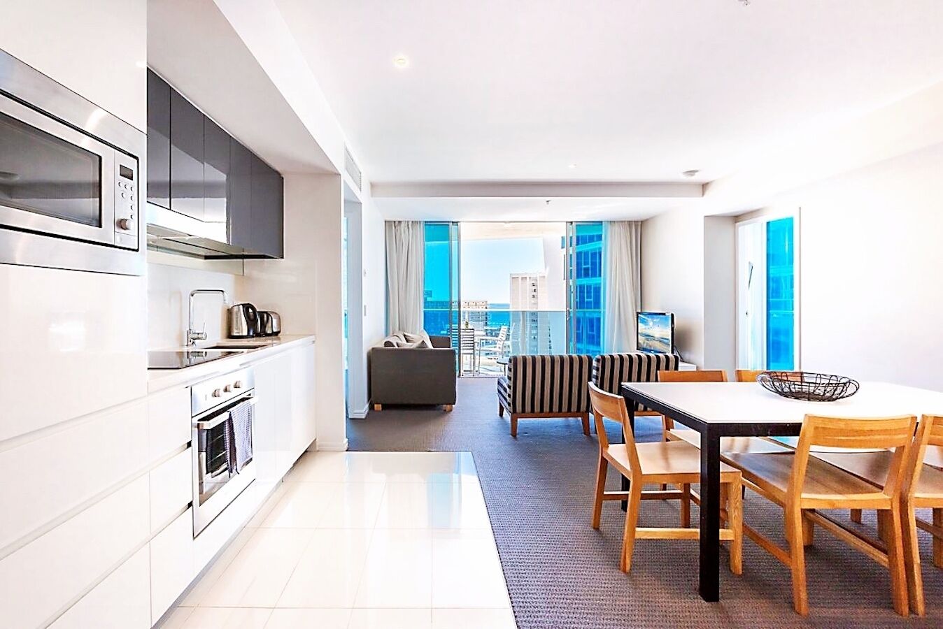 Une cuisine moderne avec un coin repas, un canapé et une vue sur la ville.