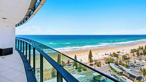 A high-rise building with a glass balcony overlooking a beach. - H Luxury Residence Apartments - Holiday Paradise (Surfers Paradise)