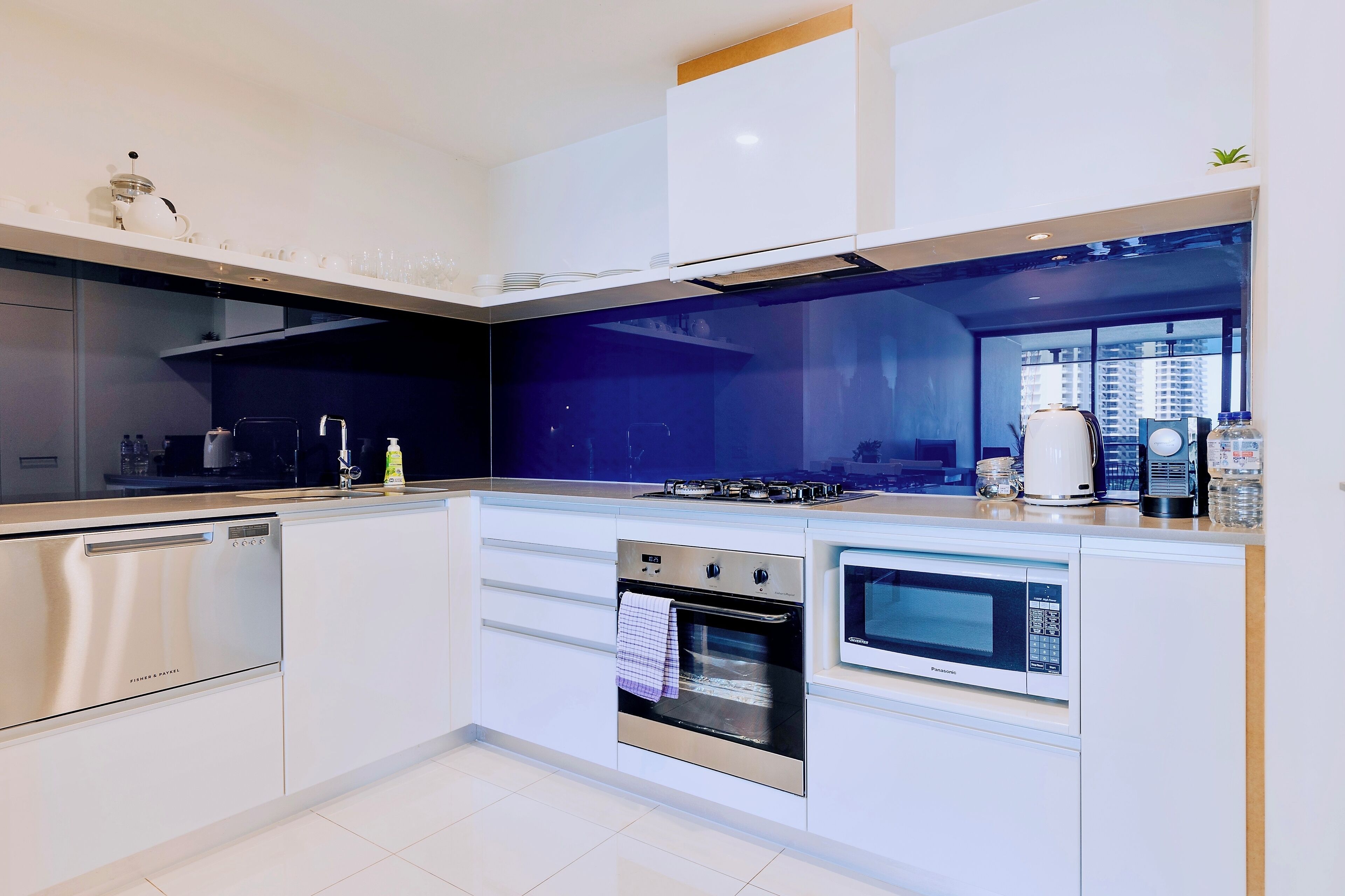 A modern kitchen with stainless steel appliances, a built-in oven, and a microwave.