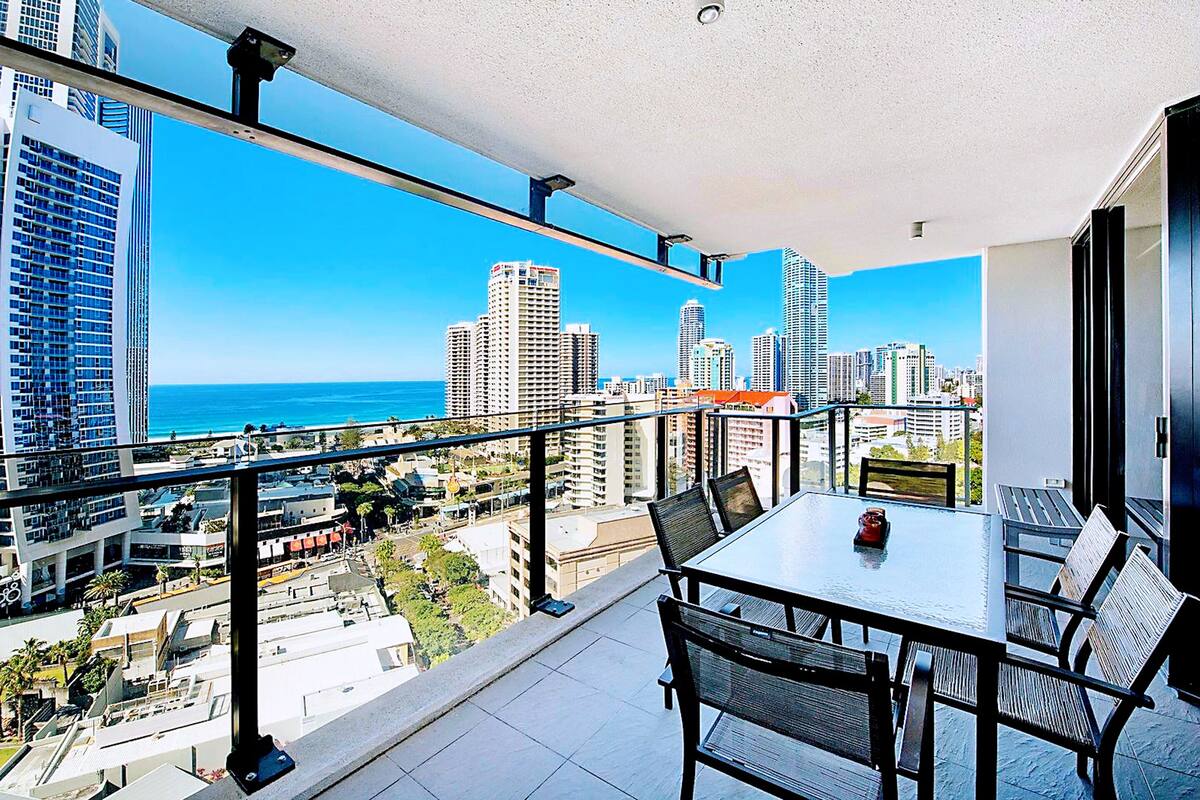 A balcony with a city view, a table, and chairs.