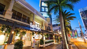 A building with a 'Betty's Burgers' sign, a 'CHEVRON' sign, and a 'The Farm' sign. - Circle On Cavill Surfers Paradise Apartments-Holiday Paradise (Surfers Paradise)