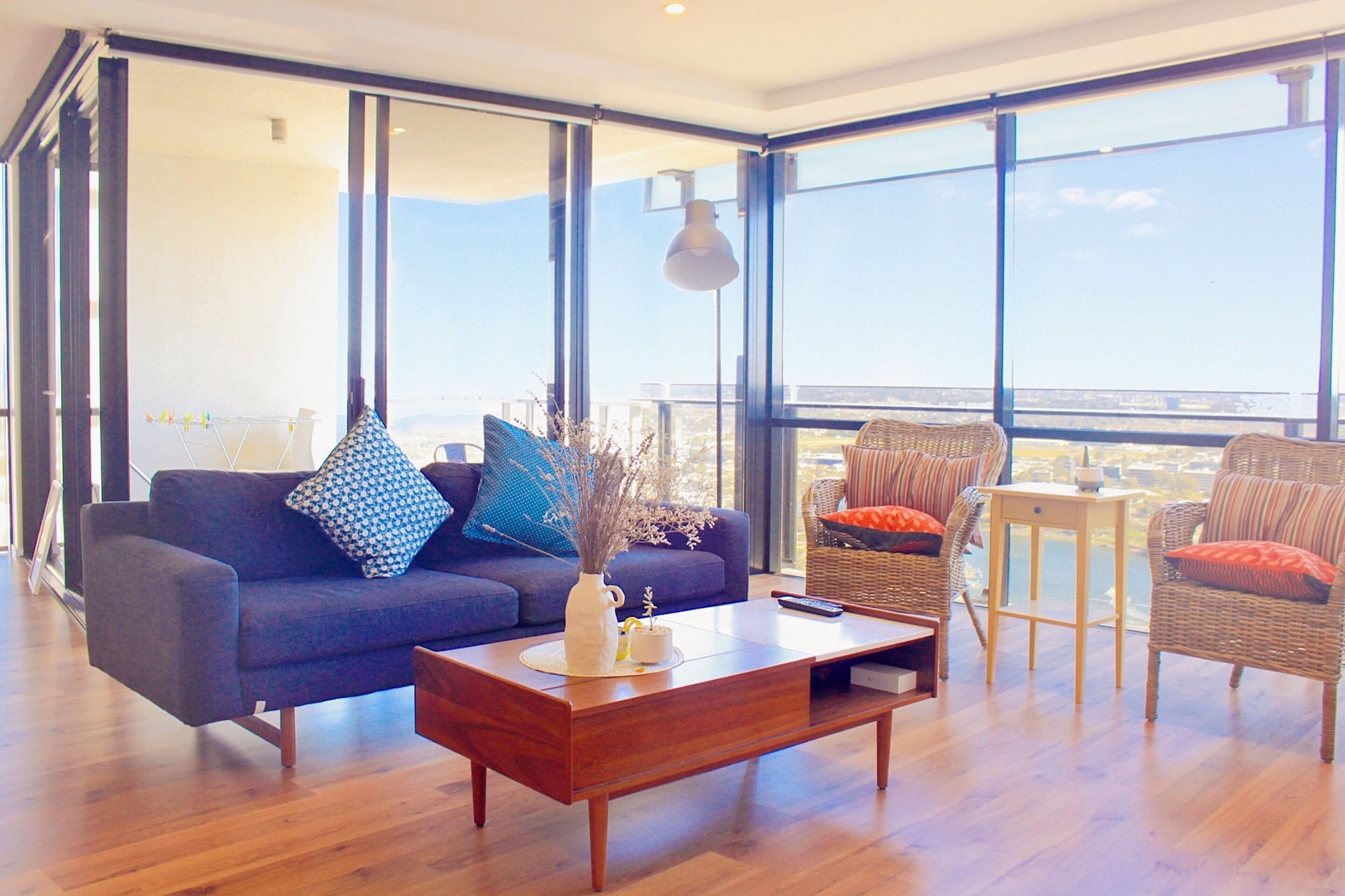 Un salon moderne avec un canapé, une table basse et des fauteuils en osier.