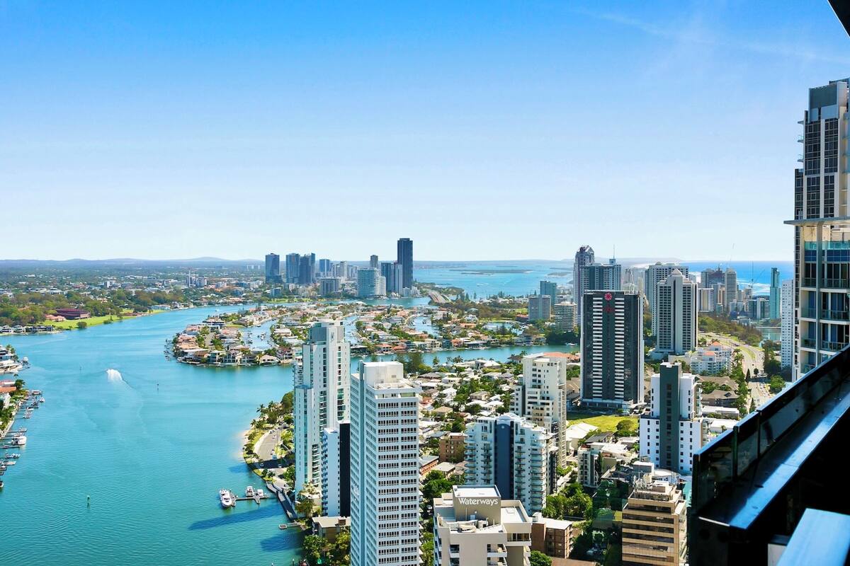 A high-rise hotel overlooking a marina with a clear view of the city skyline and water.