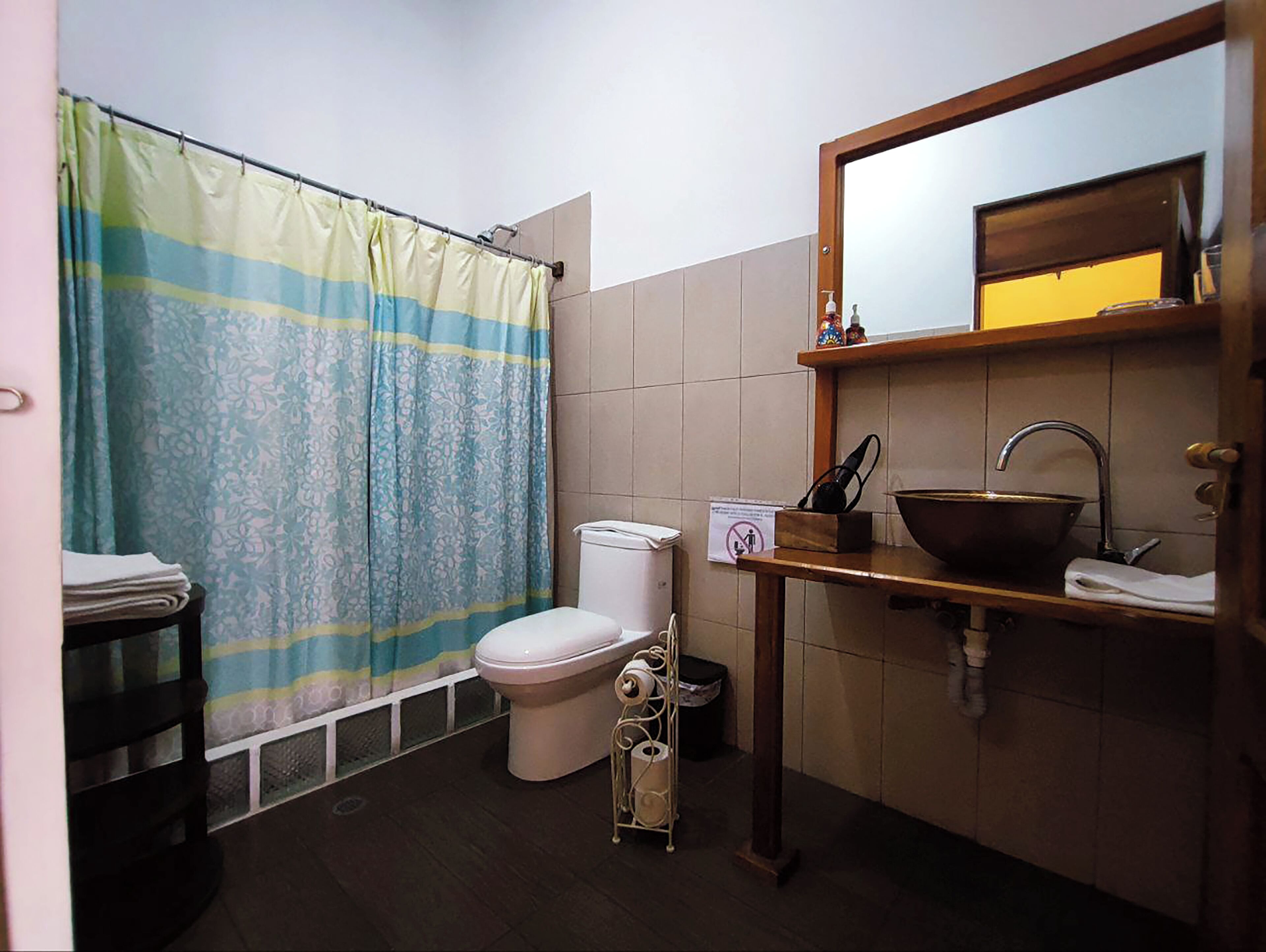 A small bathroom with a toilet, a sink, and a shower curtain.