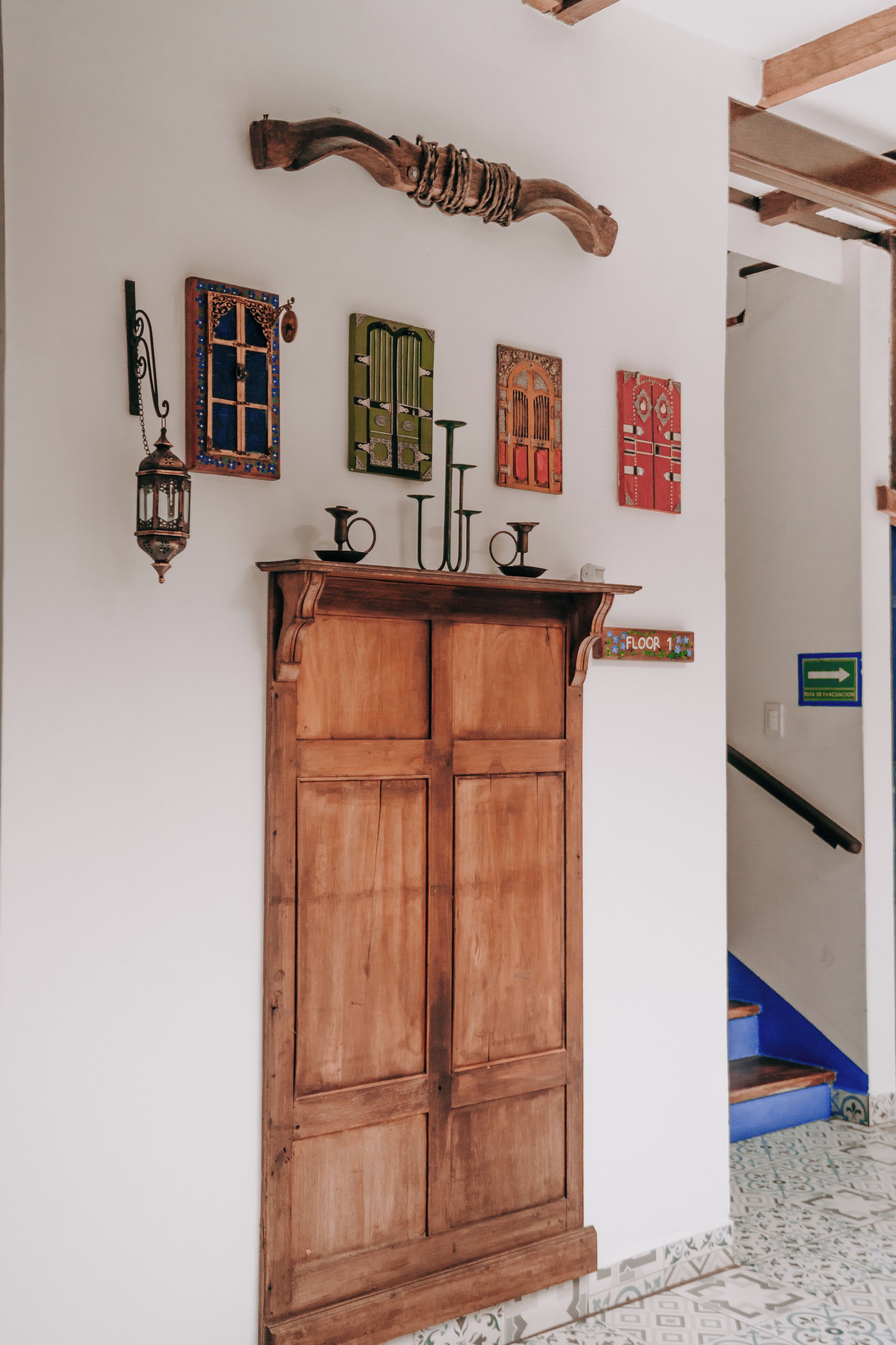 A wooden cabinet with a shelf, a wall-mounted lantern, and several decorative items including a sign indicating "Floor 1".