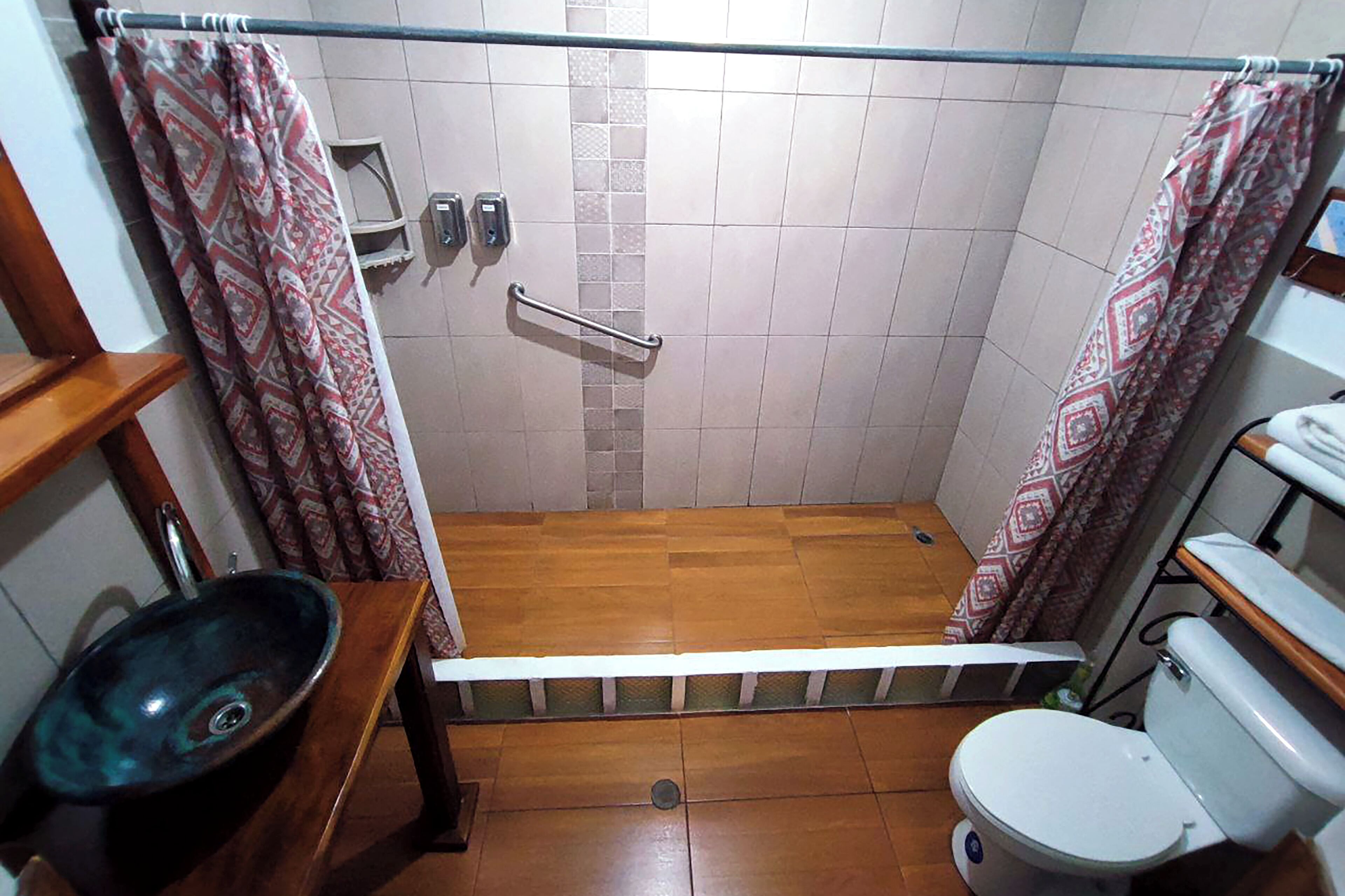 A small bathroom with a shower, toilet, and sink.