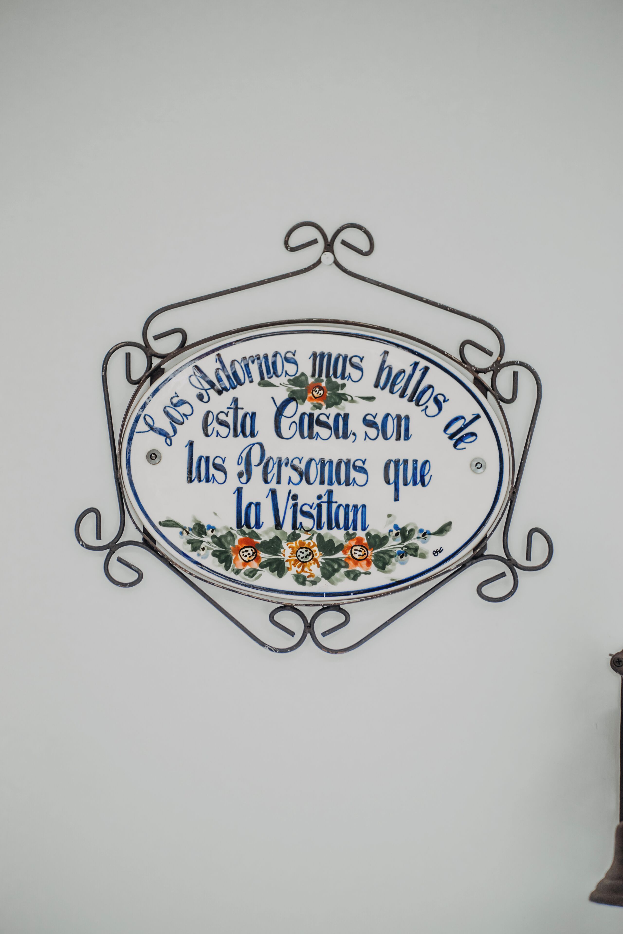 Un letrero decorativo con un borde floral y texto en español.