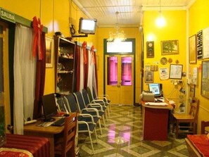 Una habitación con suelo a cuadros, una recepción, un ordenador y un televisor.