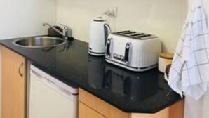 Eine kleine Küche mit Mikrowelle, Toaster und Spüle.