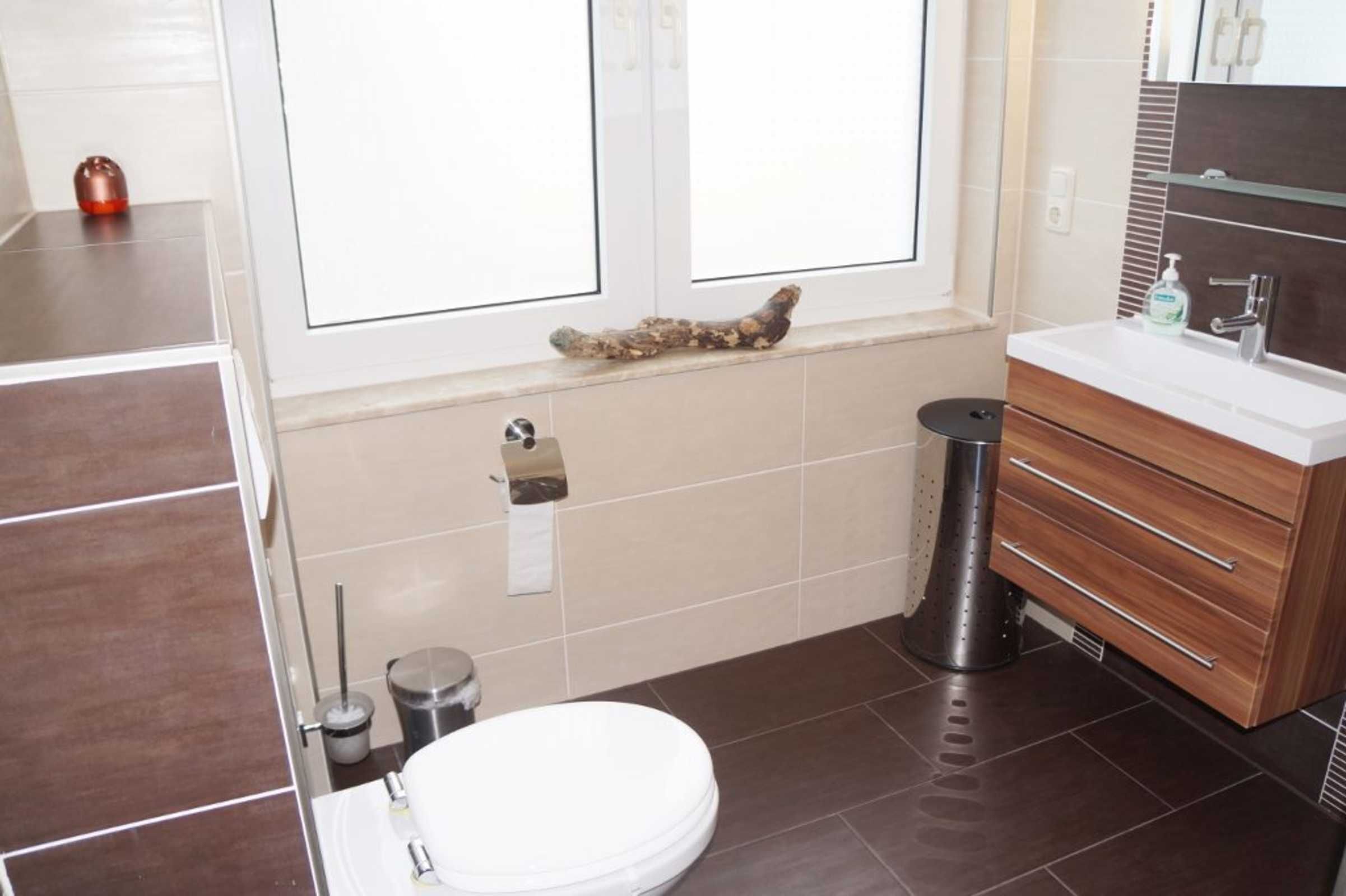 A modern bathroom with a toilet, sink, and vanity.