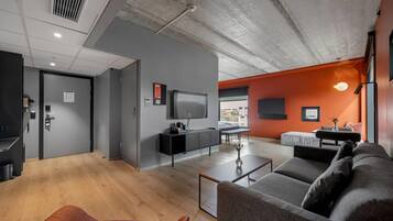 A modern living room with a grey sofa, a coffee table, and a TV mounted on the wall.