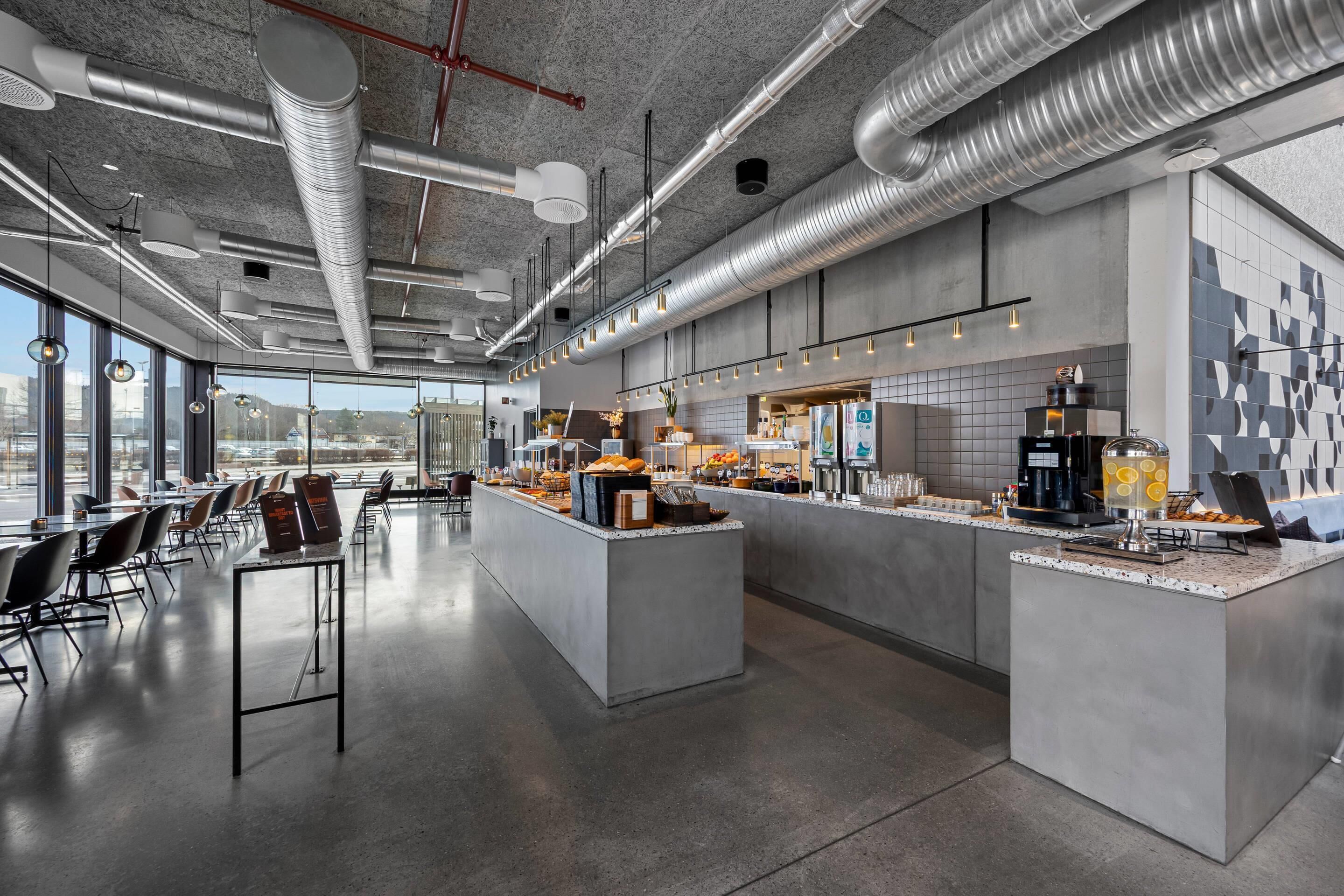 A modern kitchen with a central island, large windows, and a view of the city.