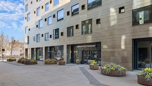 A modern hotel building with a flat facade, multiple windows, and a central entrance.