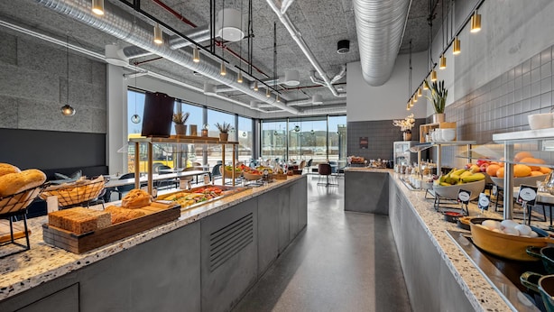 A modern kitchen with a central island, stainless steel appliances, and a view of the city.