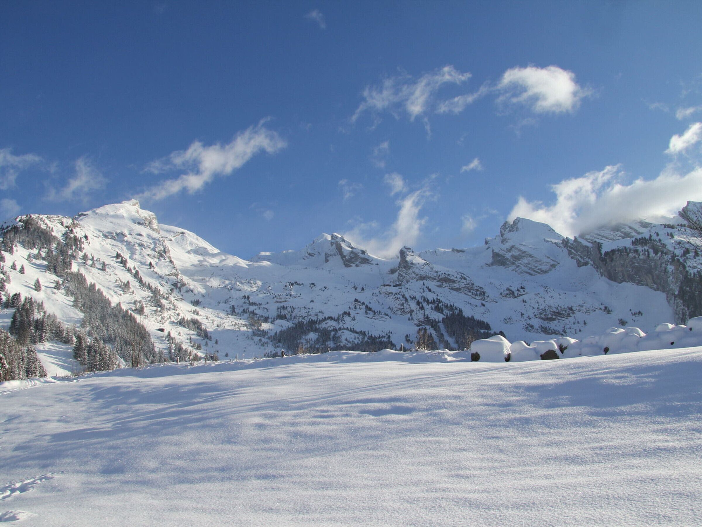 Un paysage montagneux enneigé sous un ciel dégagé.