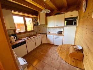 Une cuisine de taille réduite avec des meubles blancs, un four à micro-ondes et un évier.