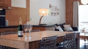 Una mesa de madera para comer con una botella de champán y dos copas.