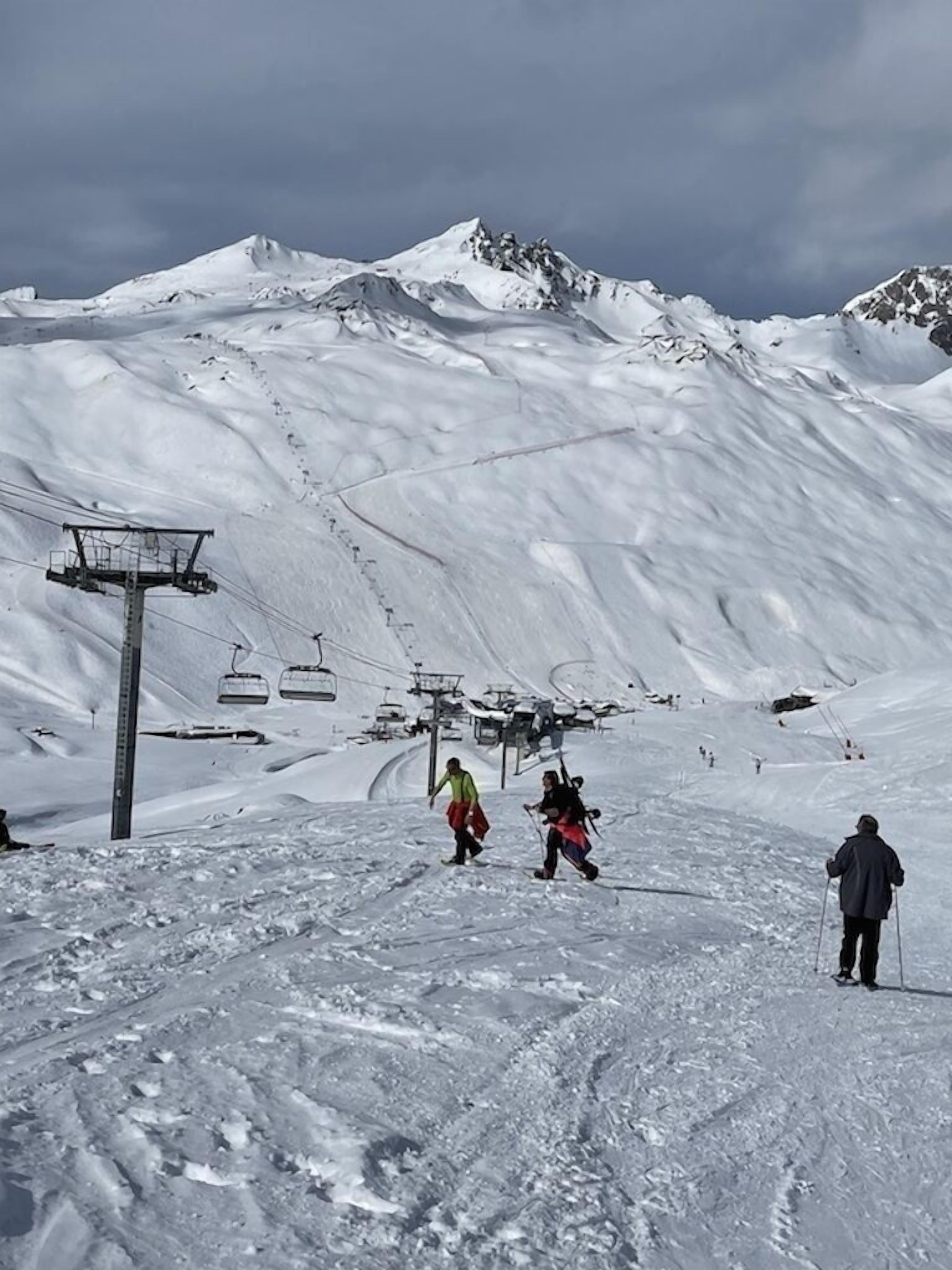 Een skipiste met een skilift en skiërs.