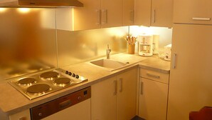 Uma cozinha compacta com fogão, pia e armários.