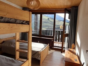 A wooden bunk bed room with a view of a mountainous landscape through large windows. - 6 Personnes - Centre haut du village (OUB190) (La Clusaz)