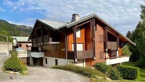 A modern two-story house with a sloped roof, wooden exterior, and a balcony on the second floor. - Simple duplex with parking in La Clusaz (La Clusaz)