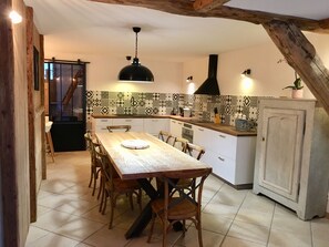 Enjoy meals at the oven and dining table in this cozy kitchen with a range hood.