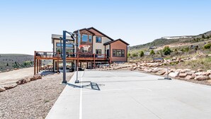 A modern two-story house with a basketball court in front.