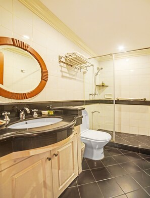 A bathroom with a round mirror, a sink, a toilet, and a shower area. - Townhouse OAK Makati Manila Near PNR Pasay Evangelista formerly VIP Suites (Makati)