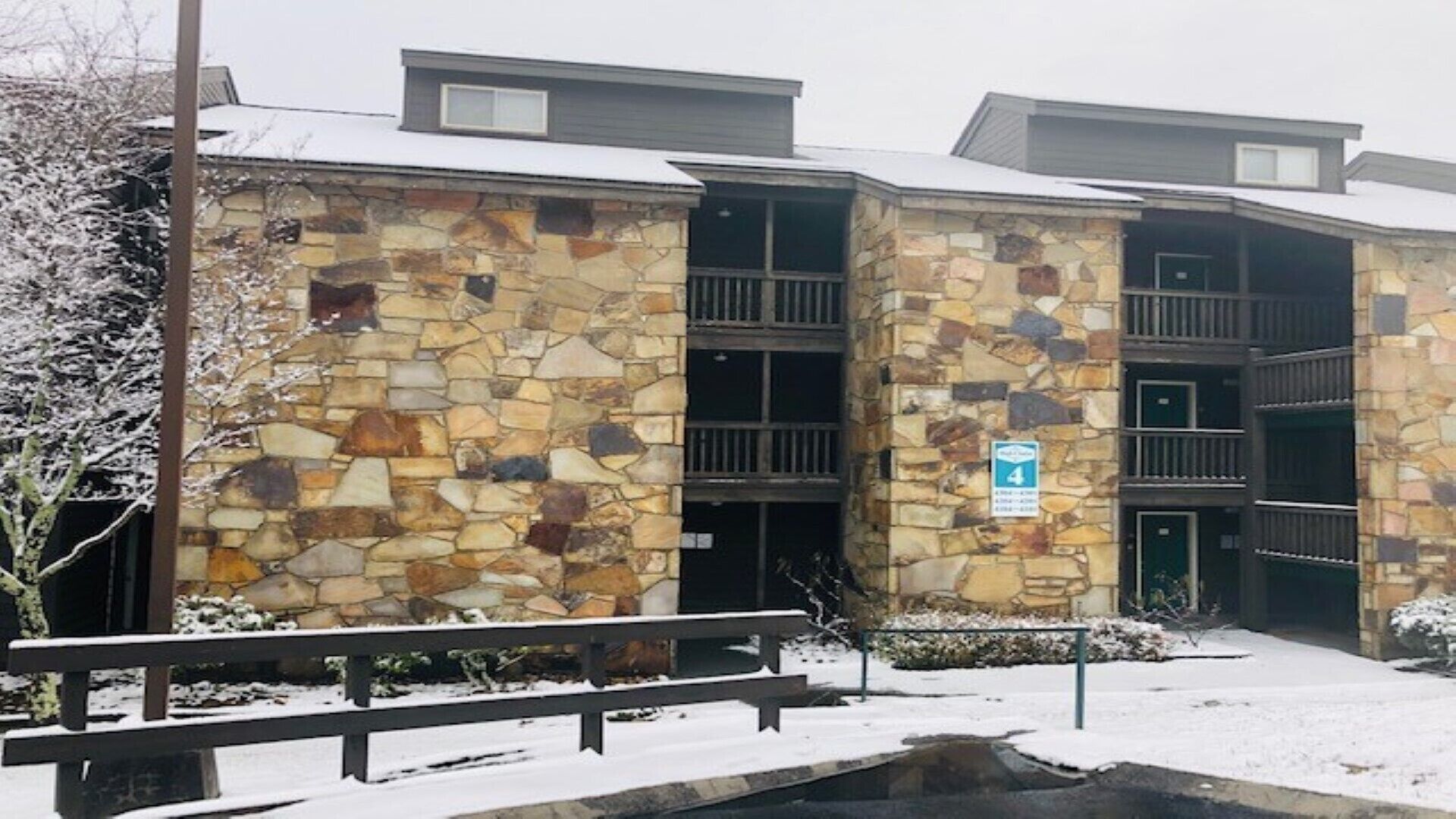 Un immeuble à plusieurs étages, doté d’une façade en pierre, d’une entrée couverte et d’une enseigne indiquant un classement quatre étoiles.