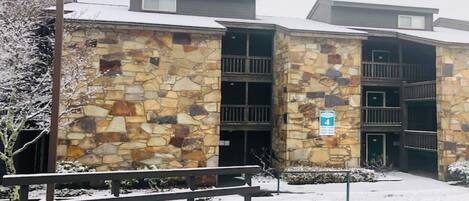 Un immeuble à plusieurs étages, doté d’une façade en pierre, d’une entrée couverte et d’une enseigne indiquant un classement quatre étoiles.
