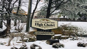 Schild für Gatlinburg High Chalet Condominiums mit verschneiter Landschaft im Hintergrund.