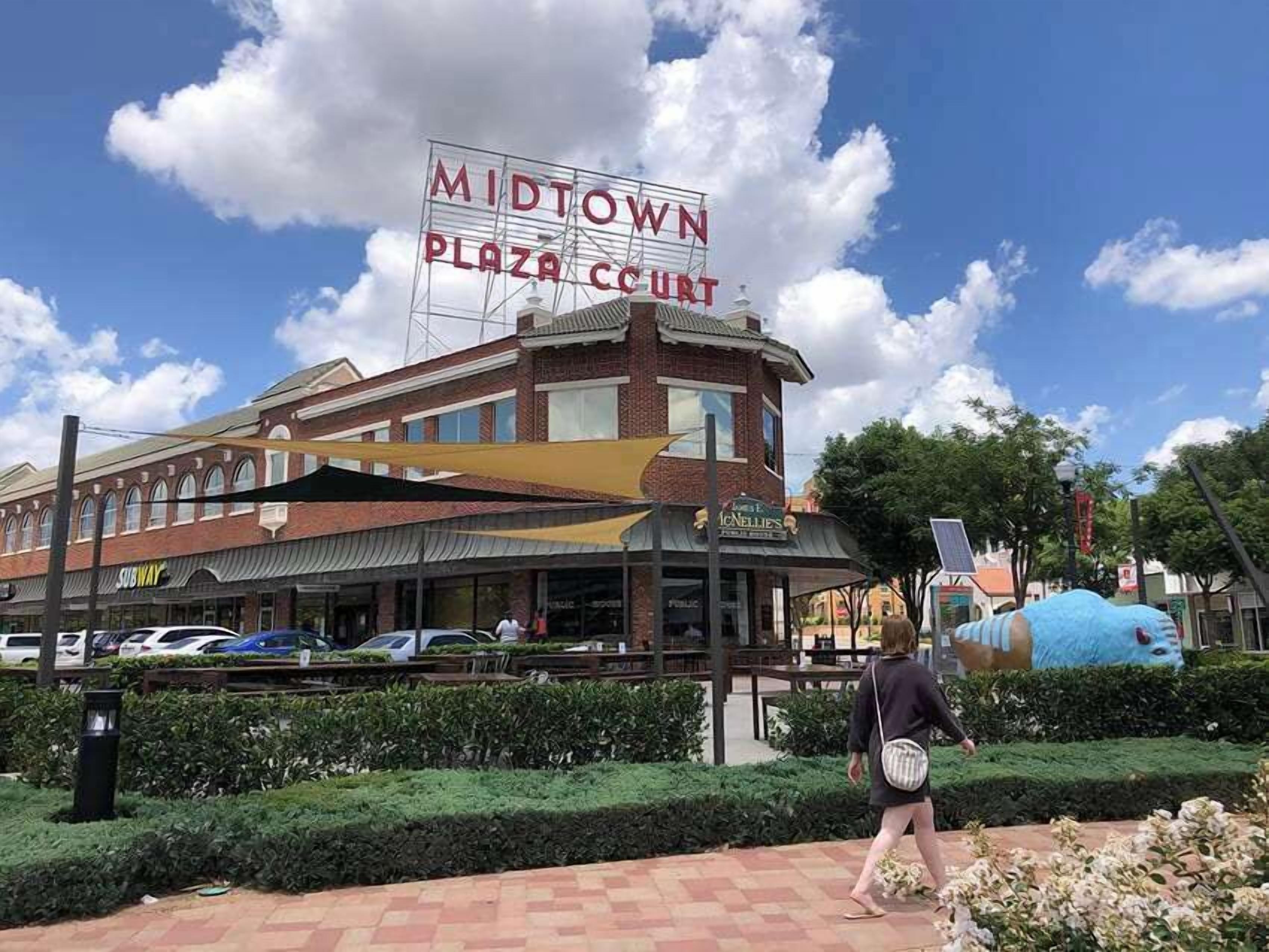 A building with a sign reading 'MIDTOWN PLAZA COURT' and a Subway restaurant.