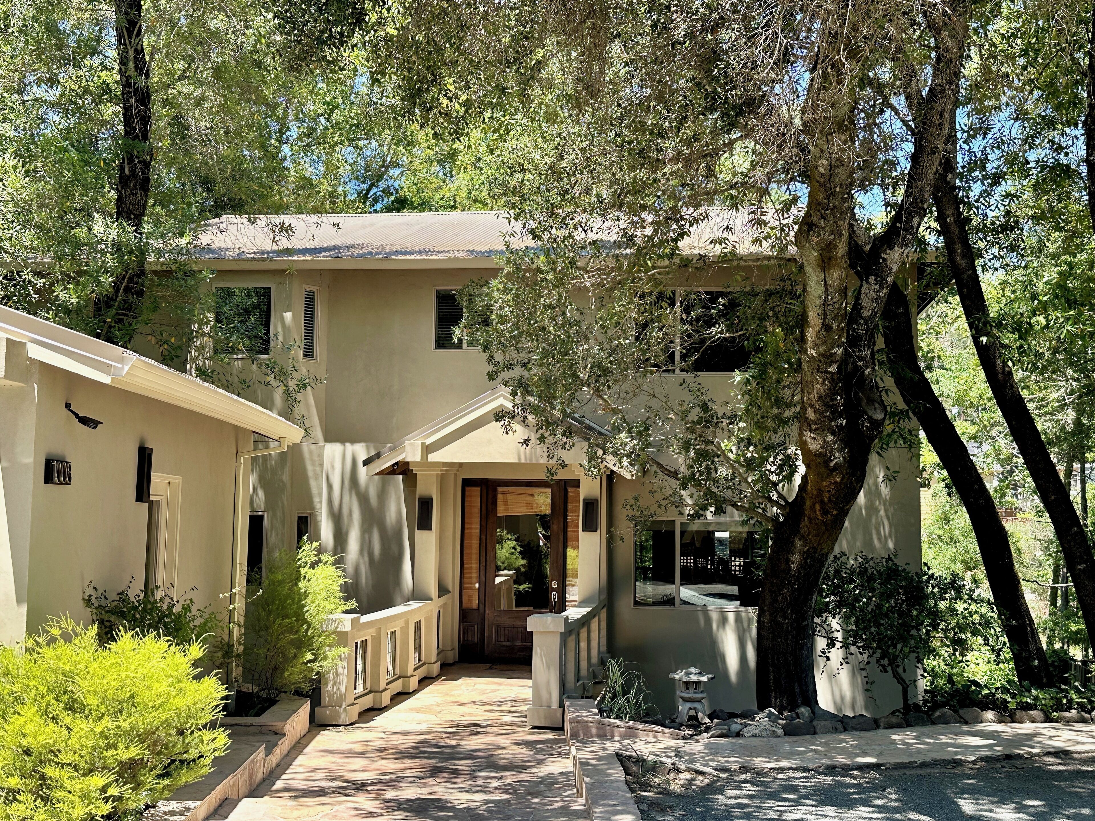 Front of house with trees providing shade.