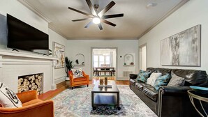 A living room with a fireplace, a ceiling fan, a sofa, a coffee table, and a TV. - Entire Lincoln Lodge by OU Medical (Oklahoma City)