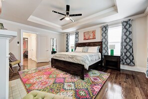 A bedroom with a bed, a ceiling fan, a patterned rug, and a window with curtains. - Howes Capitol II-Sleek & spacious-walk to OU Med (Oklahoma City)
