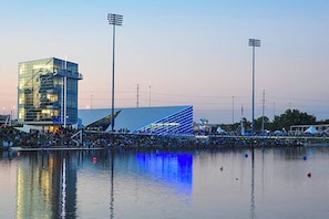 A modern building with a unique angular design, a large crowd, and a body of water reflecting the structure. - Howes Capitol II-Sleek & spacious-walk to OU Med (Oklahoma City)