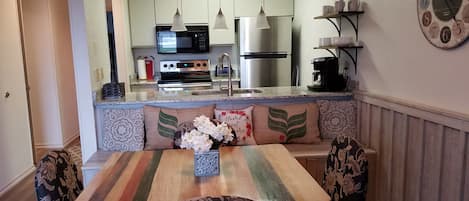 A modern kitchen with a built-in oven, microwave, and stainless steel refrigerator.