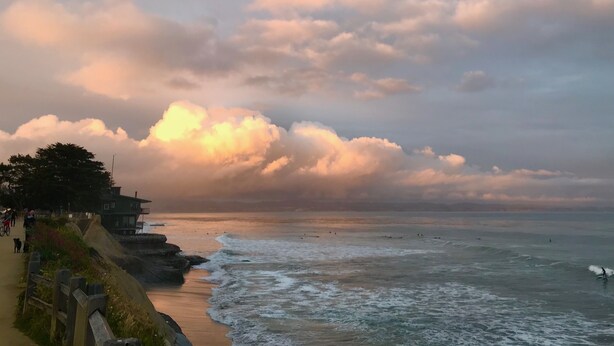 A coastal scene with a sandy beach, waves, and a cloudy sky. - Family and pet friendly close to beaches. SC Rental Permit 241396 (Santa Cruz)