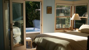 A bedroom with a bed, a window, a lamp, and a door leading to a balcony. - Family and pet friendly close to beaches. SC Rental Permit 241396 (Santa Cruz)