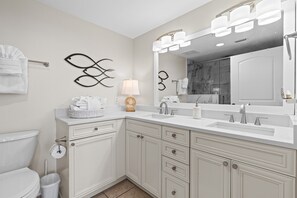 A modern bathroom with a large mirror, dual sinks, and a toilet. - Beautiful Condo with Amazing Views, Beach Service (Navarre)