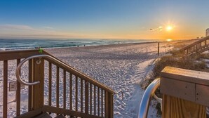 A wooden staircase leading to a beach with a clear sky and the sun setting over the ocean. - Beautiful Condo with Amazing Views, Beach Service (Navarre)