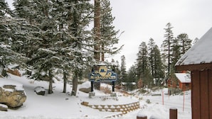 A snow-covered landscape with a sign for the Ski & Racquet Club. - Mammoth Ski & Racquet Club #78 (Mammoth Lakes)