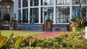 A building with large windows, outdoor seating, and potted plants. -  Beautiful beachfront villa at the Wyndham Grand R Mar Rainforest Beach Resort  (Rio Grande)