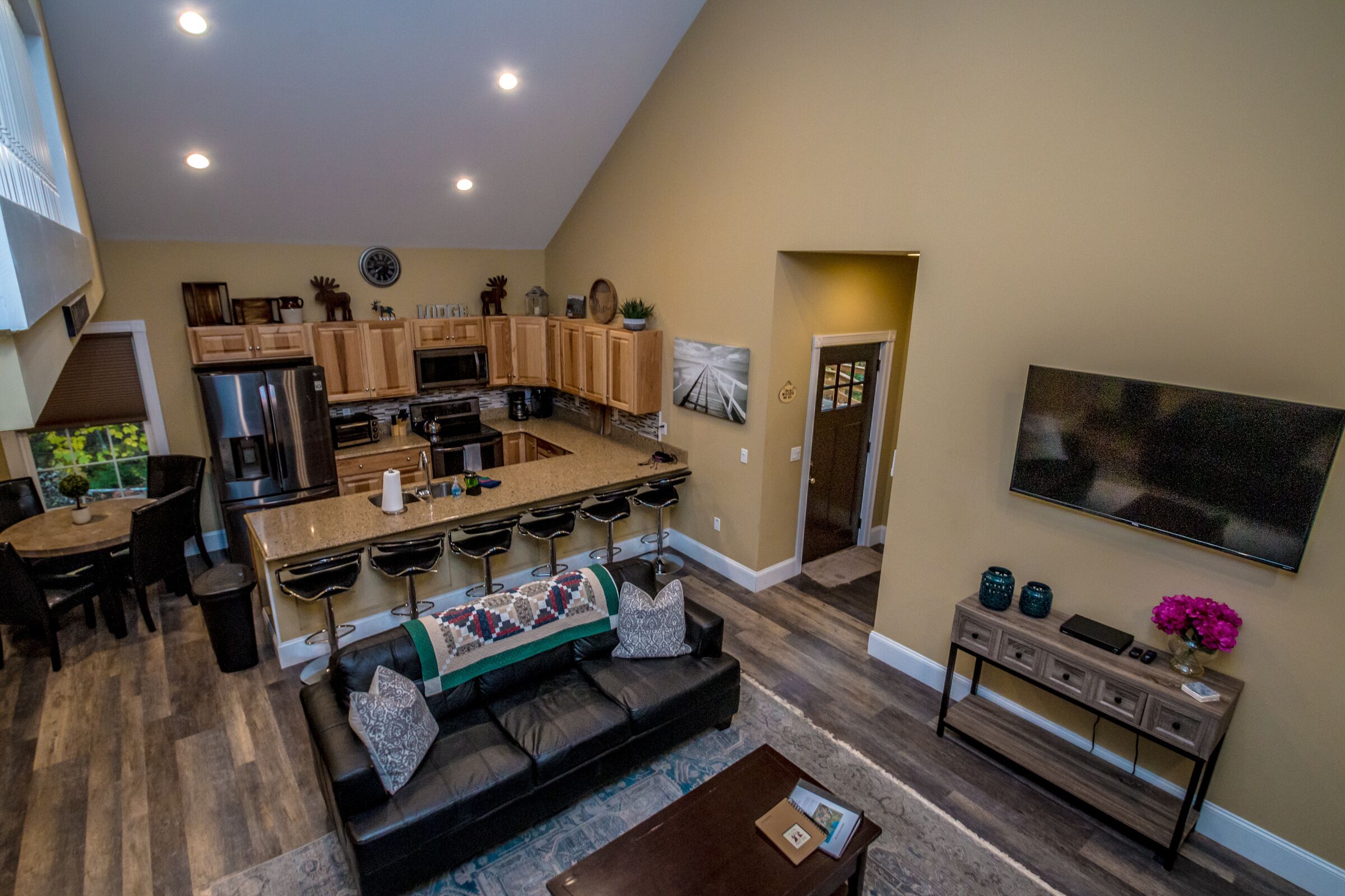 A spacious kitchen with a large island, wooden cabinets, and a dining area with a sofa and coffee table.