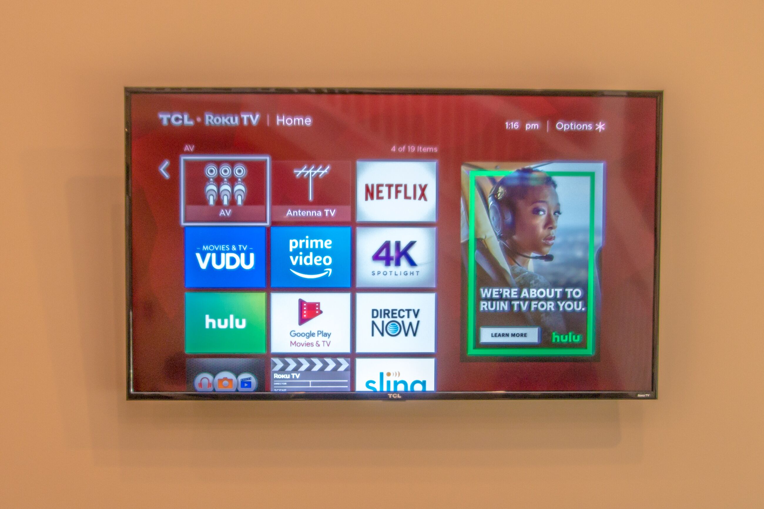 Un televisor TCL Roku con marco rojo y pantalla mostrando varios servicios de streaming.