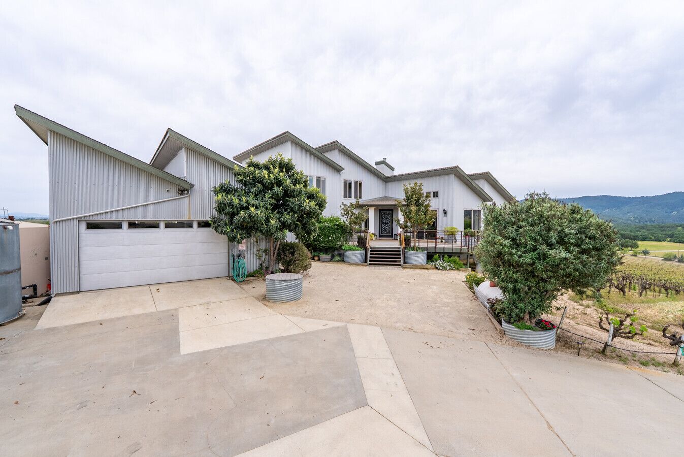 A two-story house with a garage, a front porch, and a driveway leading to the garage.