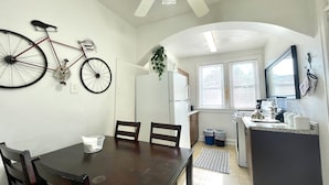A compact kitchen with a dining area, a bicycle mounted on the wall, and a ceiling fan. - 6653 2S | Jewel of Central St. Louis (St. Louis)